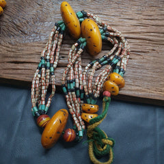 340 grams Handcrafted Amber Resin and Glass Beads Necklace. This exquisite adornment isn't just a necklace; it's a journey through time, a testament to the enduring allure of vintage aesthetics.  Crafted with meticulous attention to detail, each element of this necklace tells a story. The warm, honeyed hues of amber resin, captured within delicate glass beads, evoke a sense of timeless beauty. 
