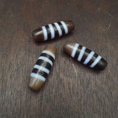"Image of 3 vintage Himalayan Indo-Tibetan Dzi amulet beads, featuring a rare and sacred 4 stripes pattern, believed to bring spiritual protection, good fortune, and blessings in Tibetan Buddhism."