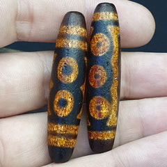 "Two pieces of Tibetan-Chinese-Nepalese Himalayan Agate 'eyes' beads, serving as Dzi amulet beads. These rare and precious beads feature distinctive eye patterns, believed to bring good fortune, protection, and spiritual growth to the wearer. Originating from the Himalayan region, they embody the cultural heritage and spiritual significance of Tibetan Buddhism."