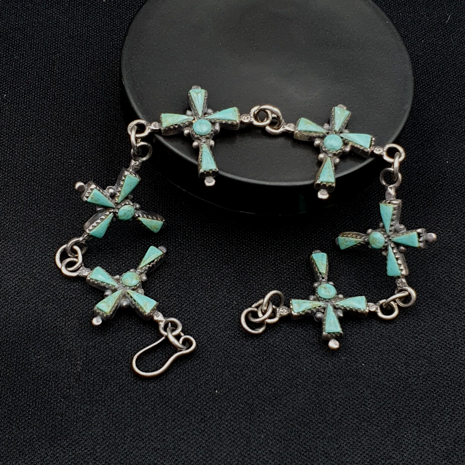 "Vintage sterling silver bracelet featuring a natural turquoise cross pendant, showcasing a vibrant blue-green stone with unique veining patterns, set in a intricately detailed silver setting, evoking a sense of classic Southwestern style and elegance."