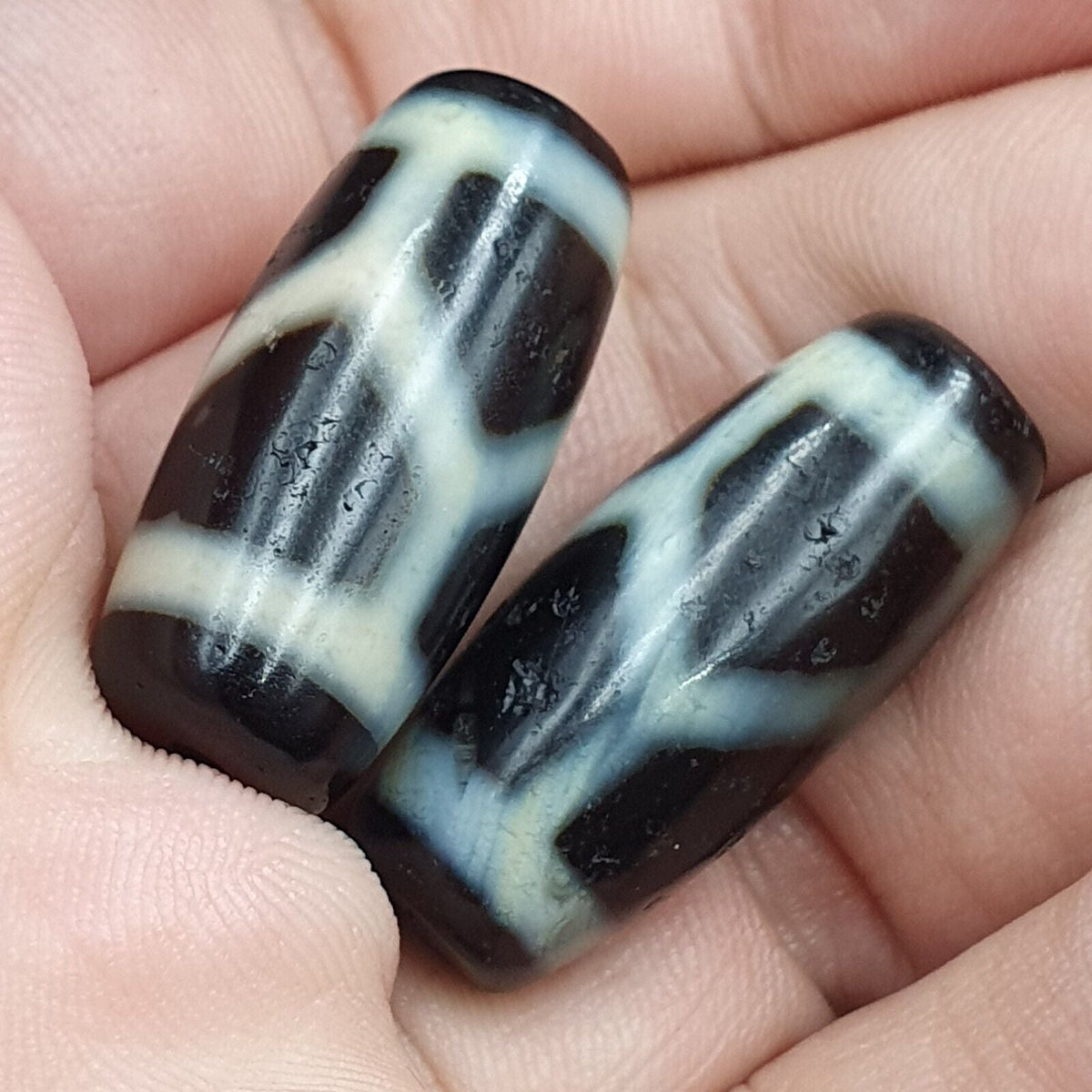 "Two antique Himalayan Indo-Tibetan Agate beads, featuring unique and intricate patterns, typically found in Dzi beads. These rare and precious beads are highly valued for their spiritual significance and cultural heritage, and are believed to bring good fortune and protection to the wearer."