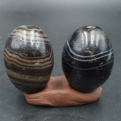 "Image of 2 ancient antique agate Suleimani beads with intricate pure patterns, used as an amulet for religious purposes, showcasing antiquities from a bygone era."