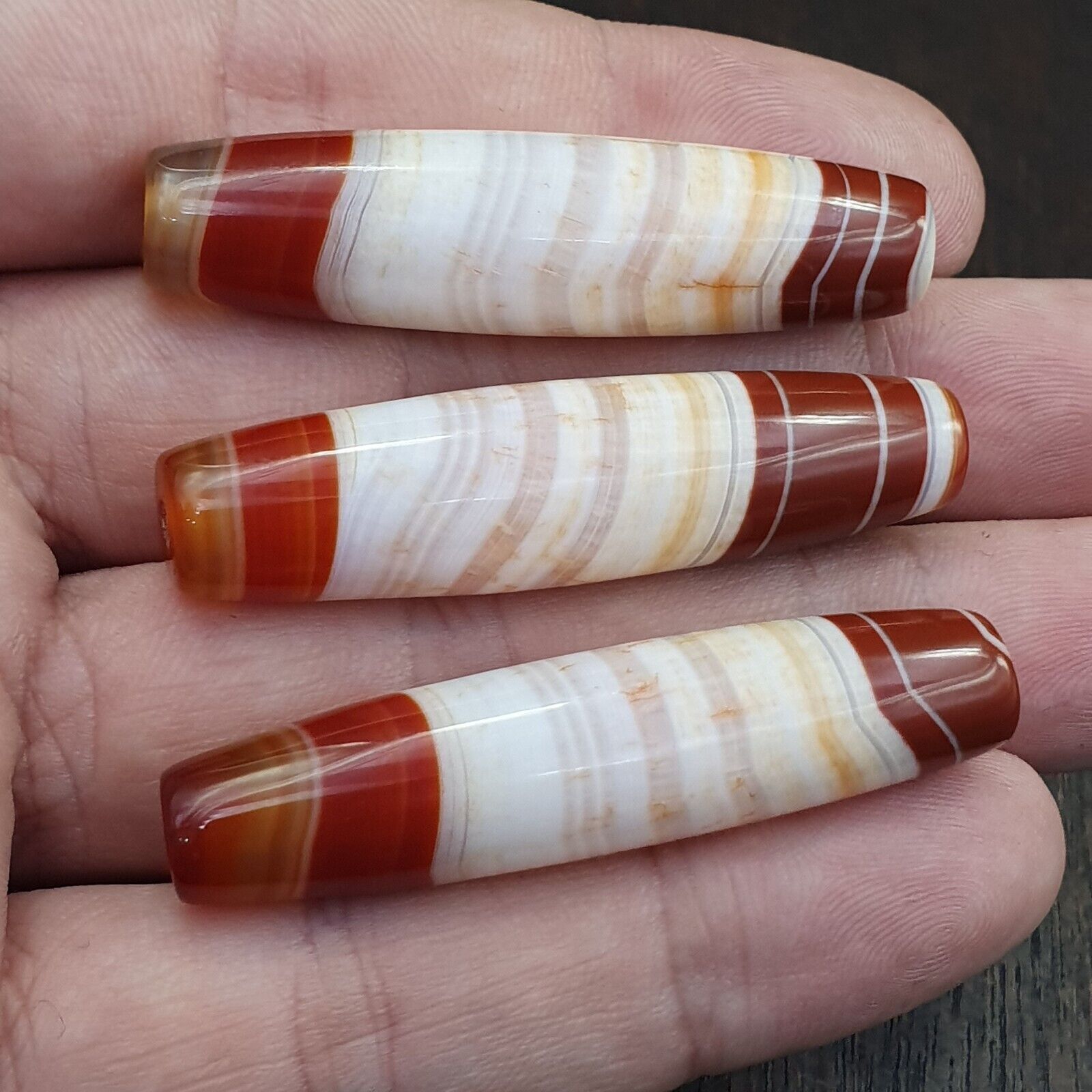 "Image of 3 rare and vintage Himalayan Tibetan amulet beads made from red agate, showcasing very rare and intricate patterns, believed to possess spiritual powers and bring protection, good fortune, and blessings in Tibetan Buddhism."