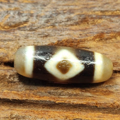 "Two antique Tibetan Agate Dzi beads, featuring diamond-shaped eyes and showcasing exceptional craftsmanship. These high-quality beads, designated as #122, are highly prized for their spiritual significance, cultural heritage, and rarity, and are believed to bring good fortune, protection, and blessings to the wearer as an amulet."