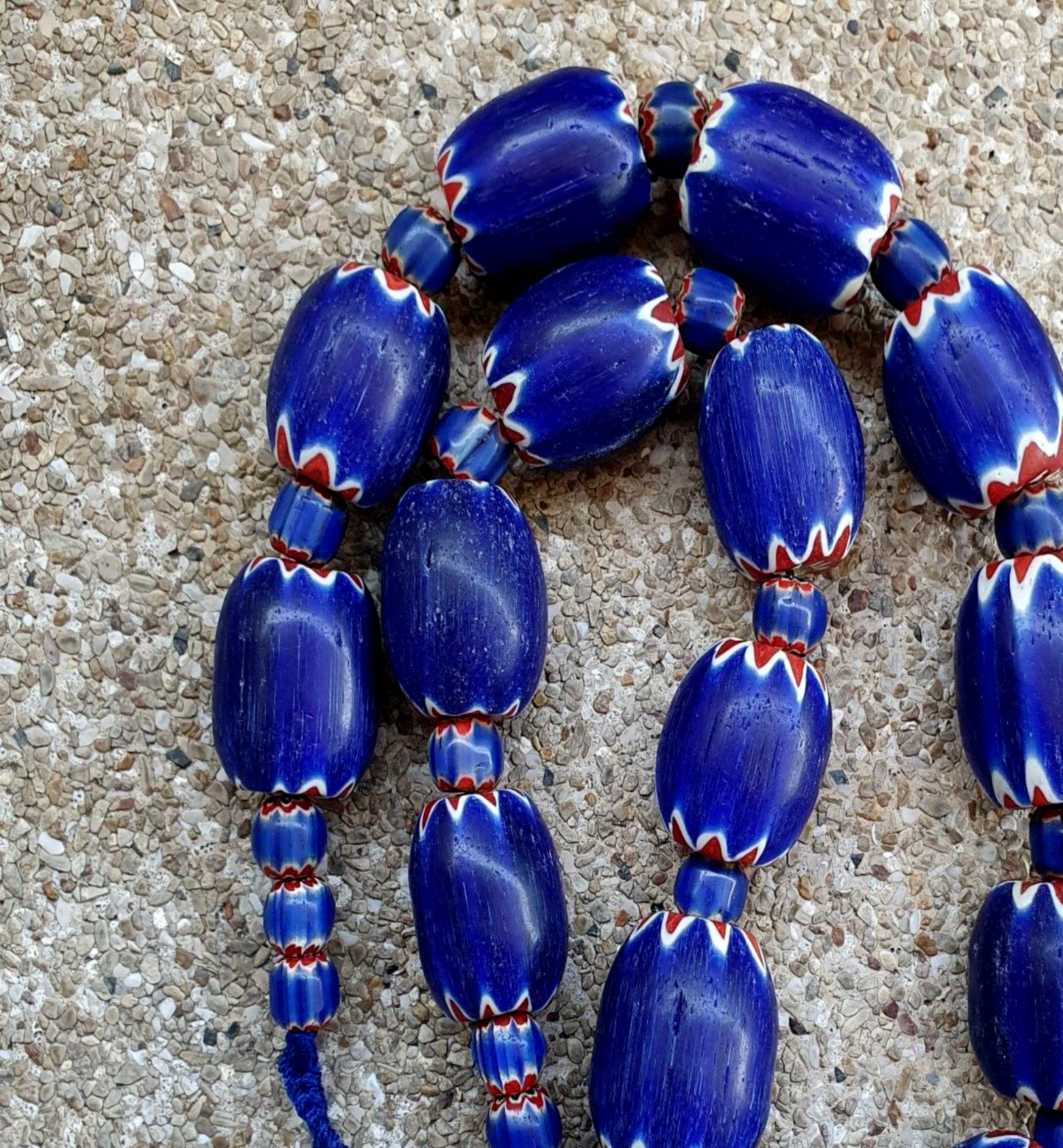 "Venetian style Blue Chevron Glass Beads Big Size Long Strand. A striking long strand of large, blue chevron-patterned glass beads in a classic Venetian style, featuring a bold and vibrant design with a sleek, glossy finish."