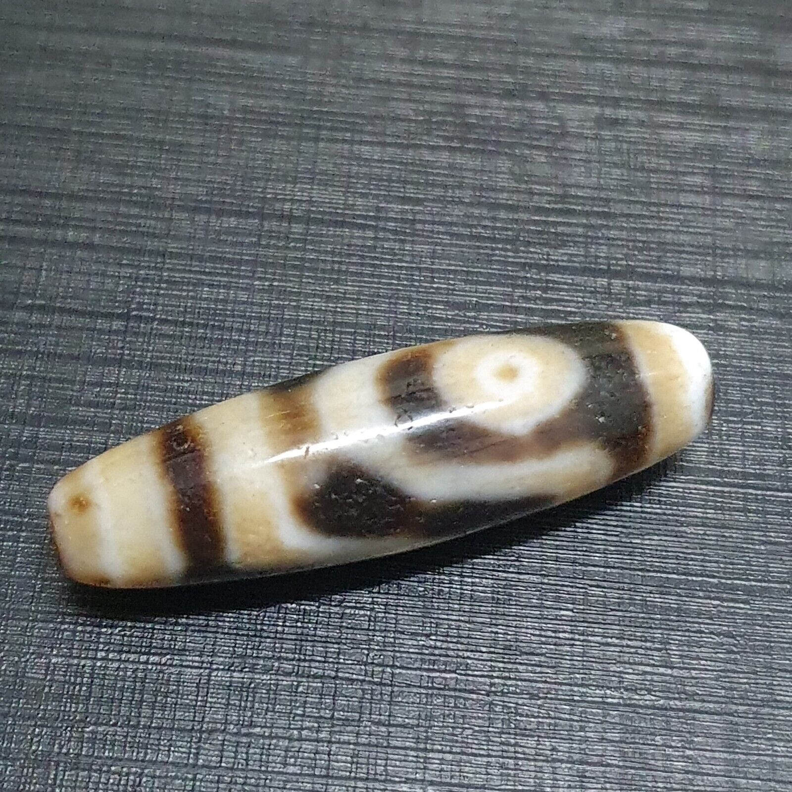 "Two antique Himalayan Indo-Tibetan Agate Dzi beads, featuring a unique 'slide eyes' pattern, highly valued for their spiritual significance and cultural heritage. These rare beads showcase an intricate design, believed to bring good fortune, protection, and blessings to the wearer. The distinctive pattern and craftsmanship make each bead a unique piece of art, originating from the Himalayan region."